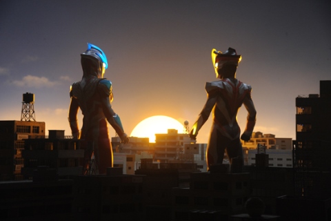 戦いが終わり、朝焼けの中に佇む、ウルトラマンギンガとウルトラマンビクトリー